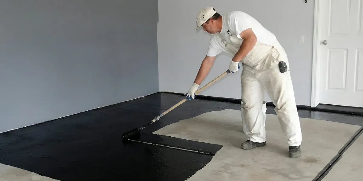 basement waterproofing professional applying waterproof coating to protect a basement floor in Cincinnati, OH